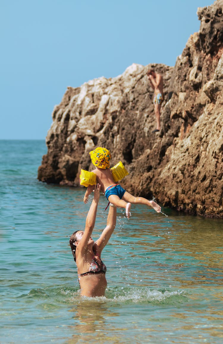 Mother And Son Swimming On The Beach