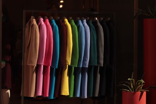 Vibrant coats hanging in a Turin boutique, showcasing a spectrum of colors.