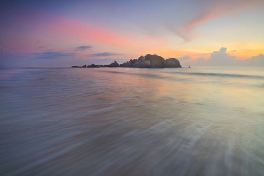 日出时，宁静的海滩上，天空柔和，海浪温柔