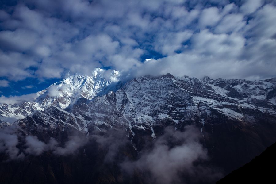 Stunning view of the snow-capped Himalayas breaking through clouds in Nepal's winter landscape.