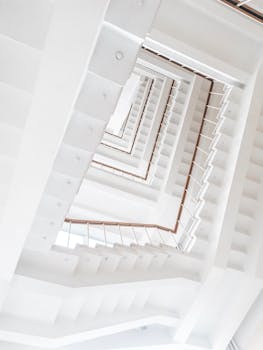 Low angle view of a modern white staircase with geometric patterns captured indoors.