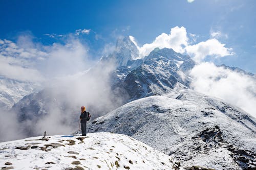 A Person Standing on a Snow-Covered Mountain