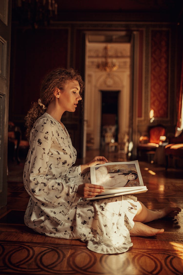 Woman In Dress Sitting In Antique House Reading Book