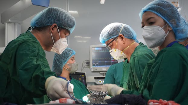 A dedicated team of surgeons working in an operating room, focused on performing a surgery under sterile conditions.