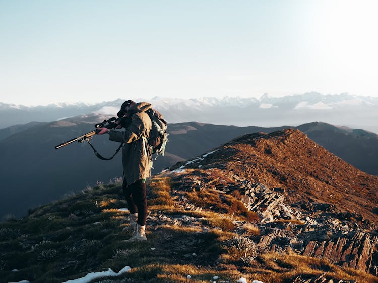 A Hunter Standing On The Top Of A Mountain