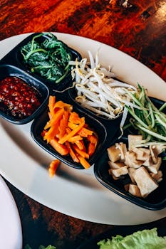 A vibrant Asian dish featuring fresh vegetables and tofu presented in a traditional setup.