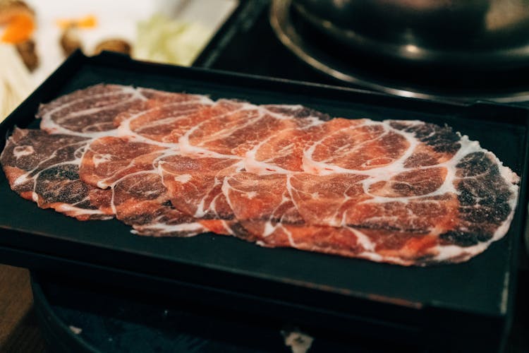 Thin Slice Of Raw Meat On Black Ceramic Plate