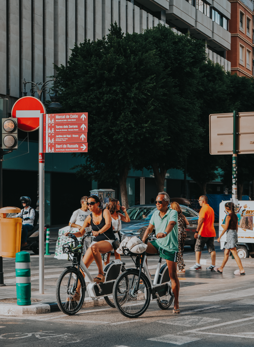 Free Street scene in Valencia with people and bicycles, capturing everyday urban life. Stock Photo