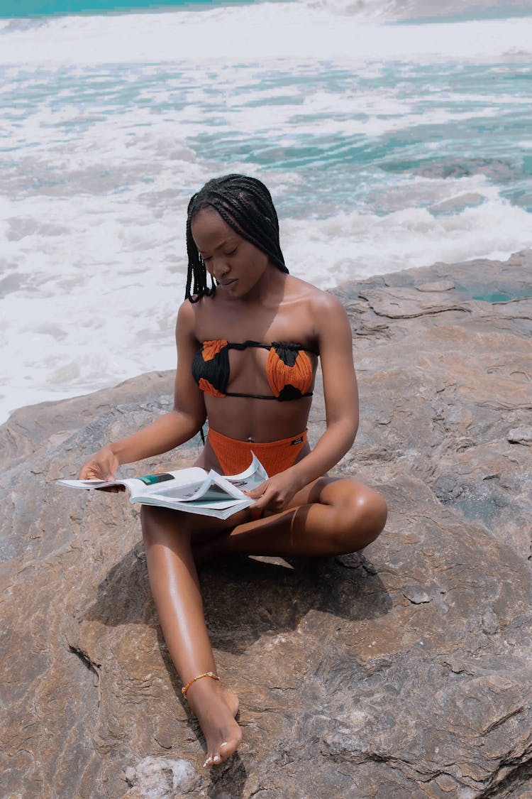 Woman In Bikini On Beach Reading Magazine