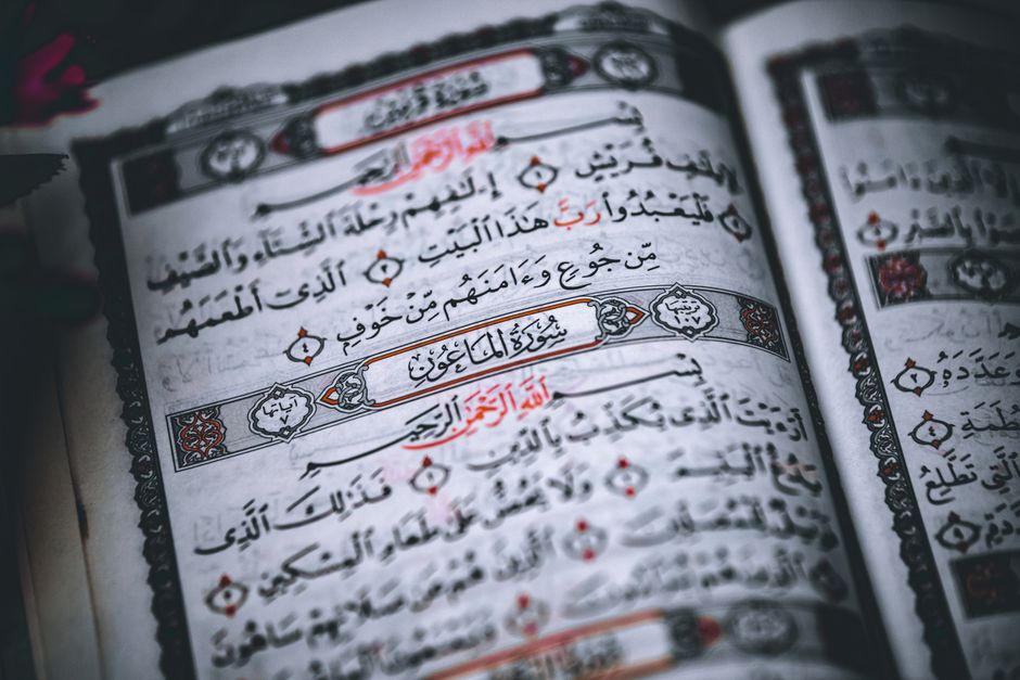 Detailed close-up of Quran pages with Arabic calligraphy in a traditional script.