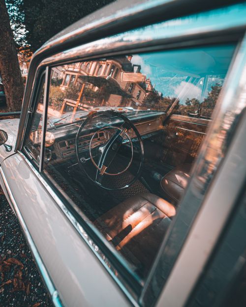 Free Detailed view of a vintage car interior reflecting historical buildings outside. Stock Photo