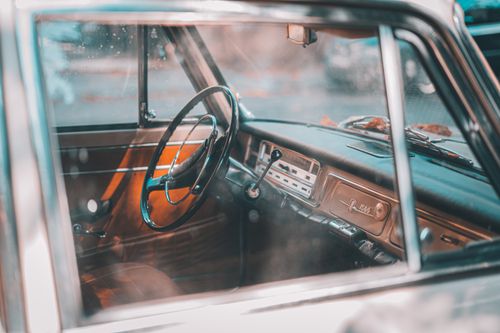 Free Close-up of a vintage car interior showcasing classic design, steering wheel, and dashboard. Stock Photo