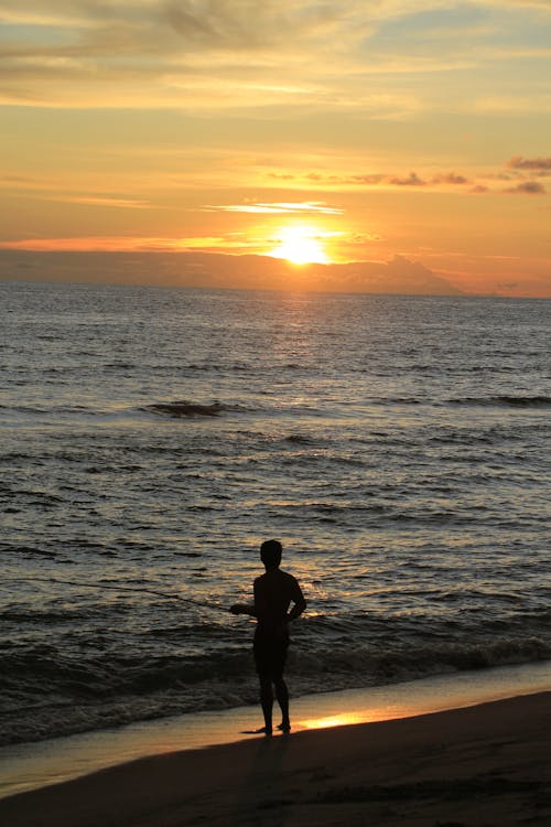 A Silhouette of a Man at the Beach during the Golden Hour