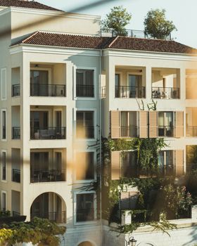 Mediterranean style building exterior with lush greenery on a sunny day.
