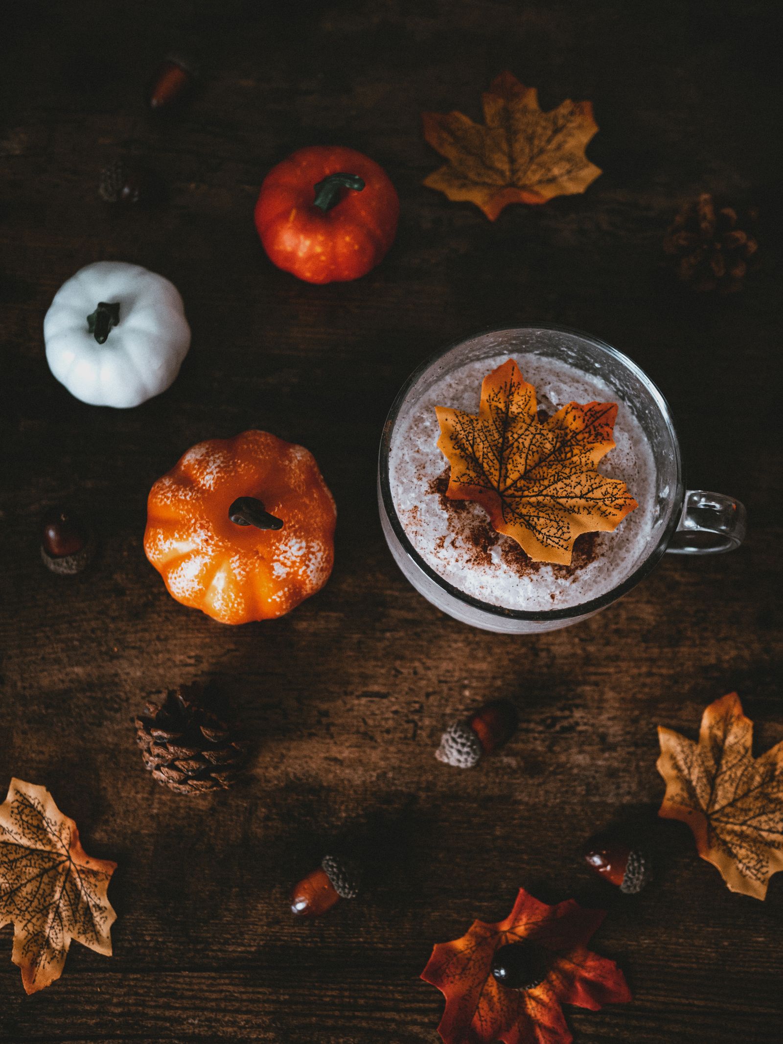 Cozy autumn nature table with a warm drink, pumpkins, and fall leaves for homeschool