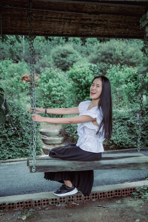 Beautiful and cute asian girl is playing on the swing