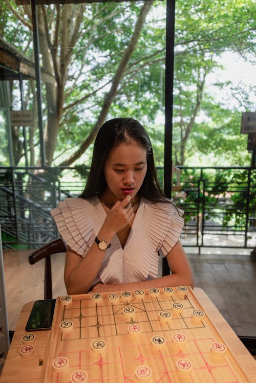 Beautiful and cute young asian girl playing chess