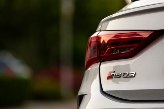 Close-up photo showcasing the tail light and logo of a sleek Audi RS Q3, highlighting its modern design.
