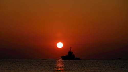 Silhouette of a Ship on Sea During Sunset