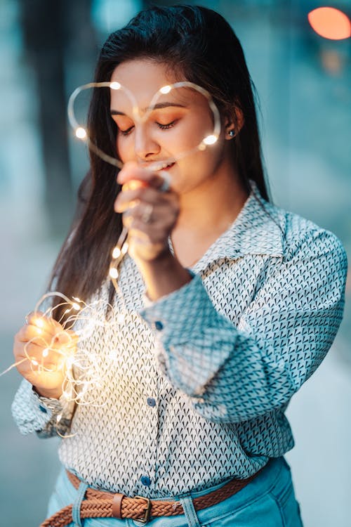 Close Up Photo of Woman Holding String Lights