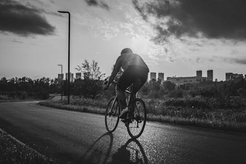 Black and White Photo of a Person Riding a Bicycle