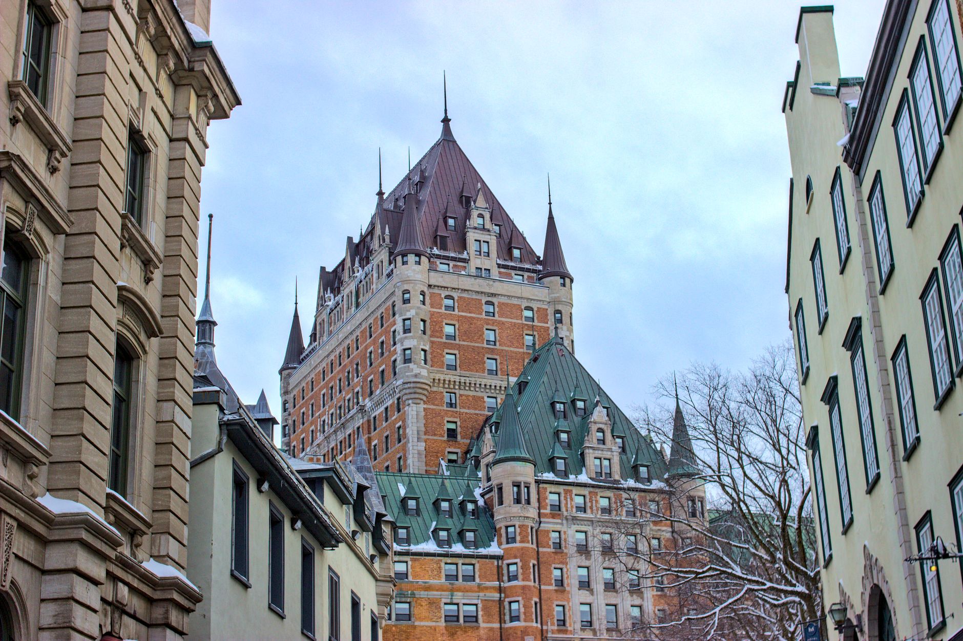 View of Château Frontenac surrounded by historic buildings in snowy Québec City, Canada. Related image for Hospitality in Canada: What Is Changing Across Global Hospitality.
