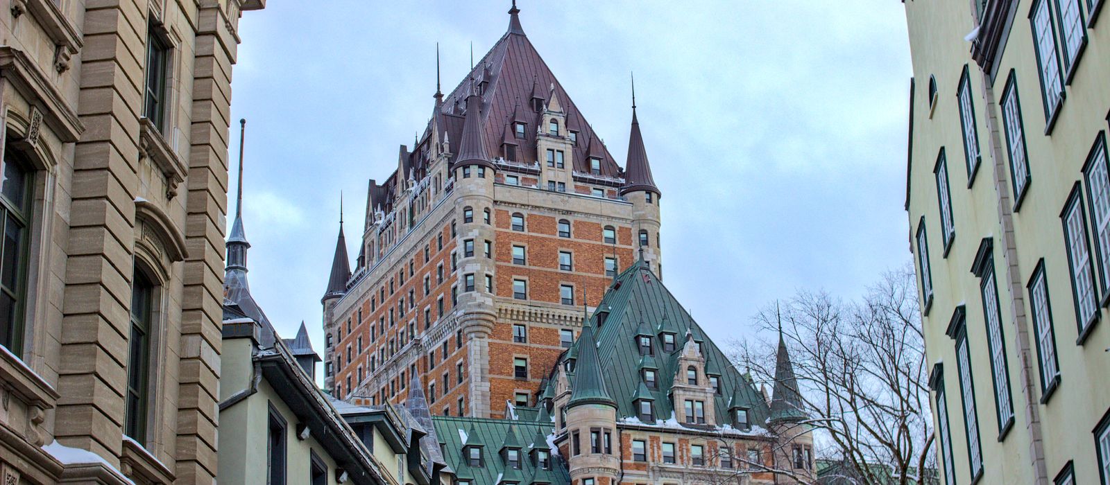 View of Château Frontenac surrounded by historic buildings in snowy Québec City, Canada.