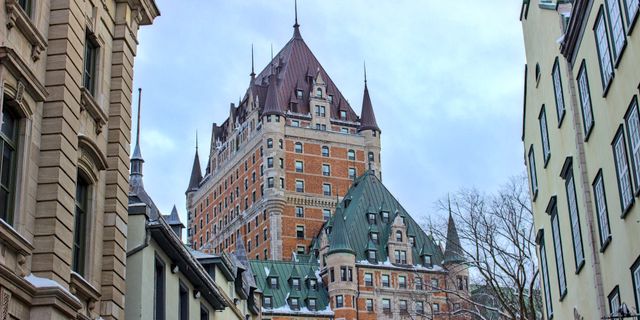 View of Château Frontenac surrounded by historic buildings in snowy Québec City, Canada.
