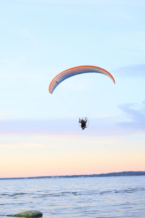 Free A thrilling paragliding scene over a tranquil lake during a scenic sunset, capturing the spirit of adventure. Stock Photo
