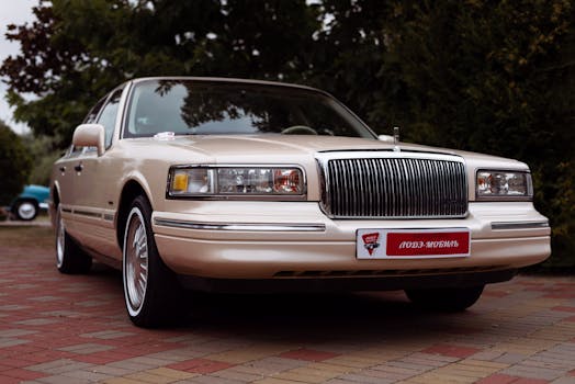 Vintage Lincoln Town Car with chrome details parked outdoors on a paved area.