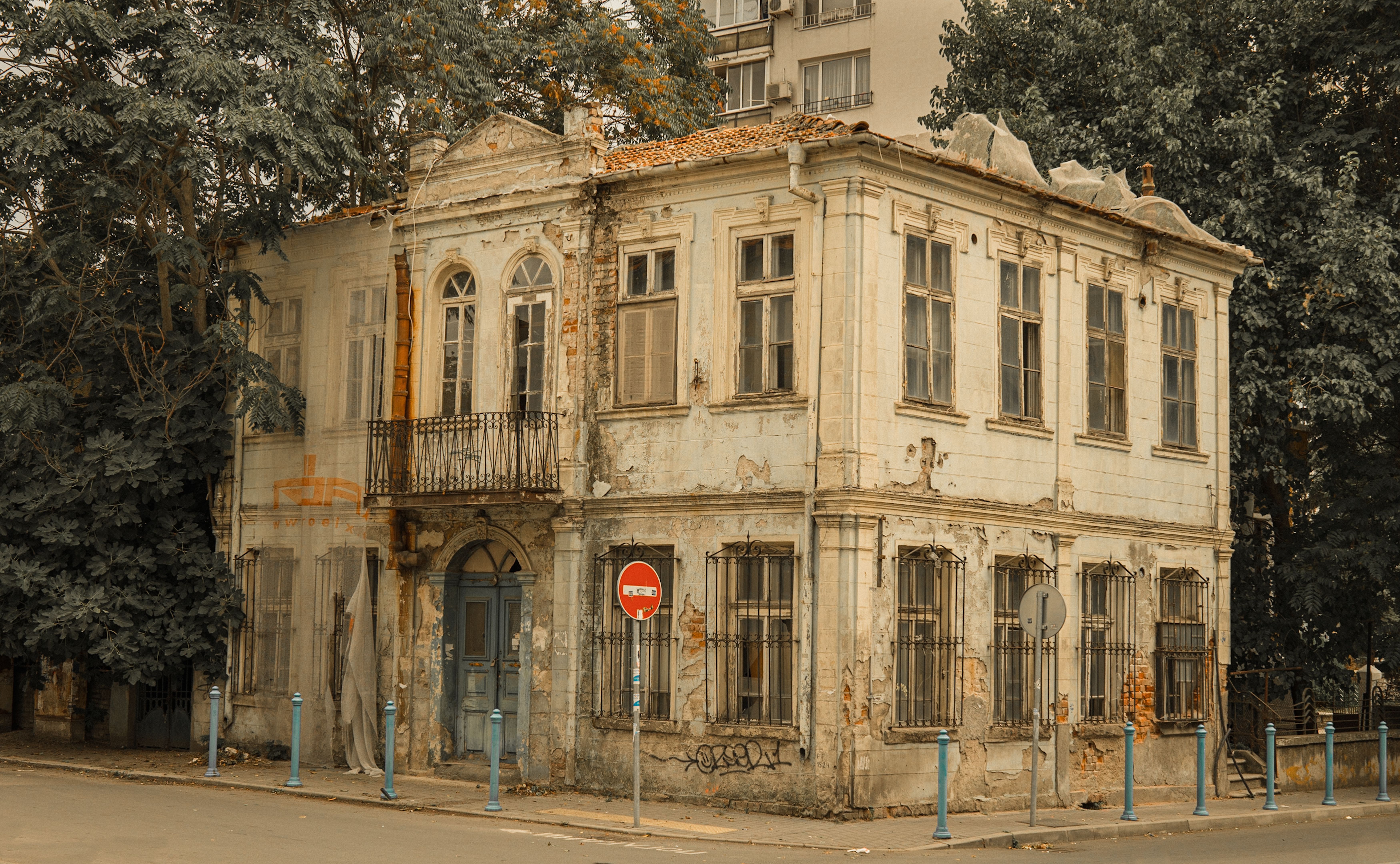 Aged and weathered building with a balcony and no entry sign.