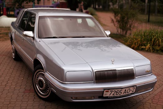 Shiny classic silver car parked on urban street, showcasing luxury and vintage style.