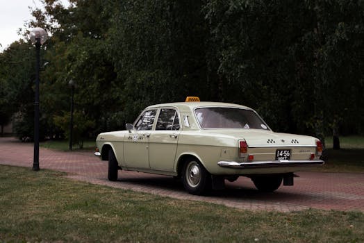 Classic vintage taxi cab parked in a serene, leafy alley, creating a nostalgic ambiance.