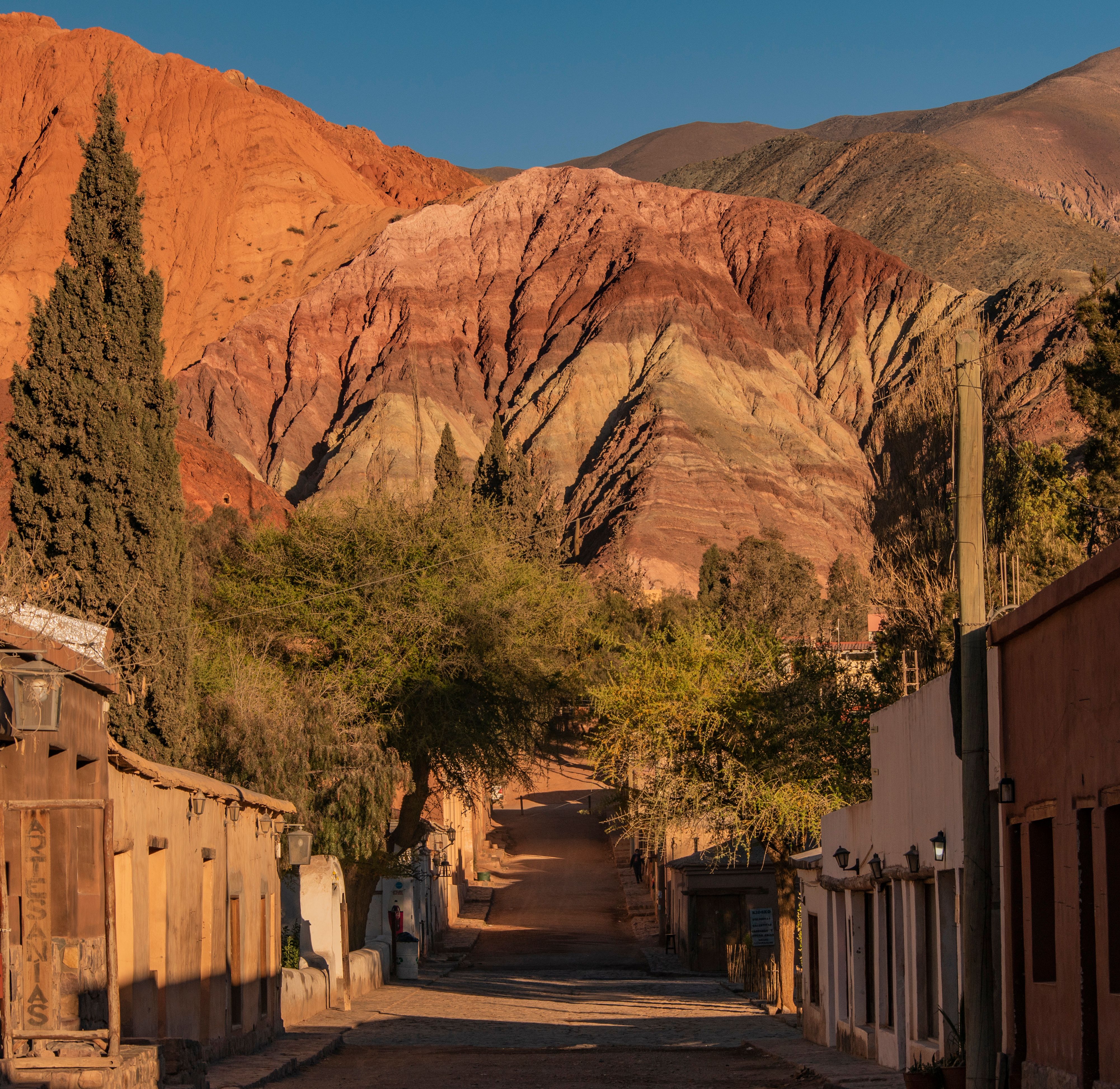 Dirt street in Purmamarca with adobe houses and the coloured hills behind