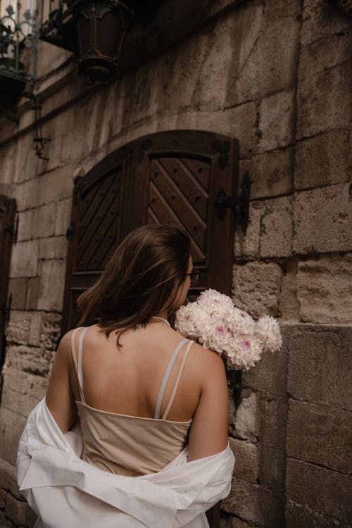 Základová fotografie zdarma na téma bílé šaty košile, chryzantémy, cihlová budova