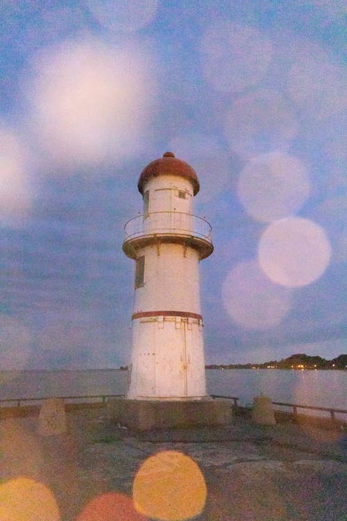 White Concrete Lighthouse Under Blue Sky