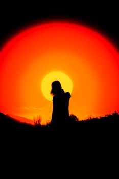 Silhouette of a person against a dramatic sunset in Cide, Kastamonu, Türkiye. Vibrant colors fill the sky.