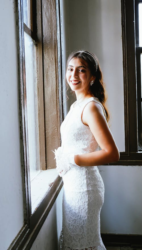 Woman in White Dress Beside the Window