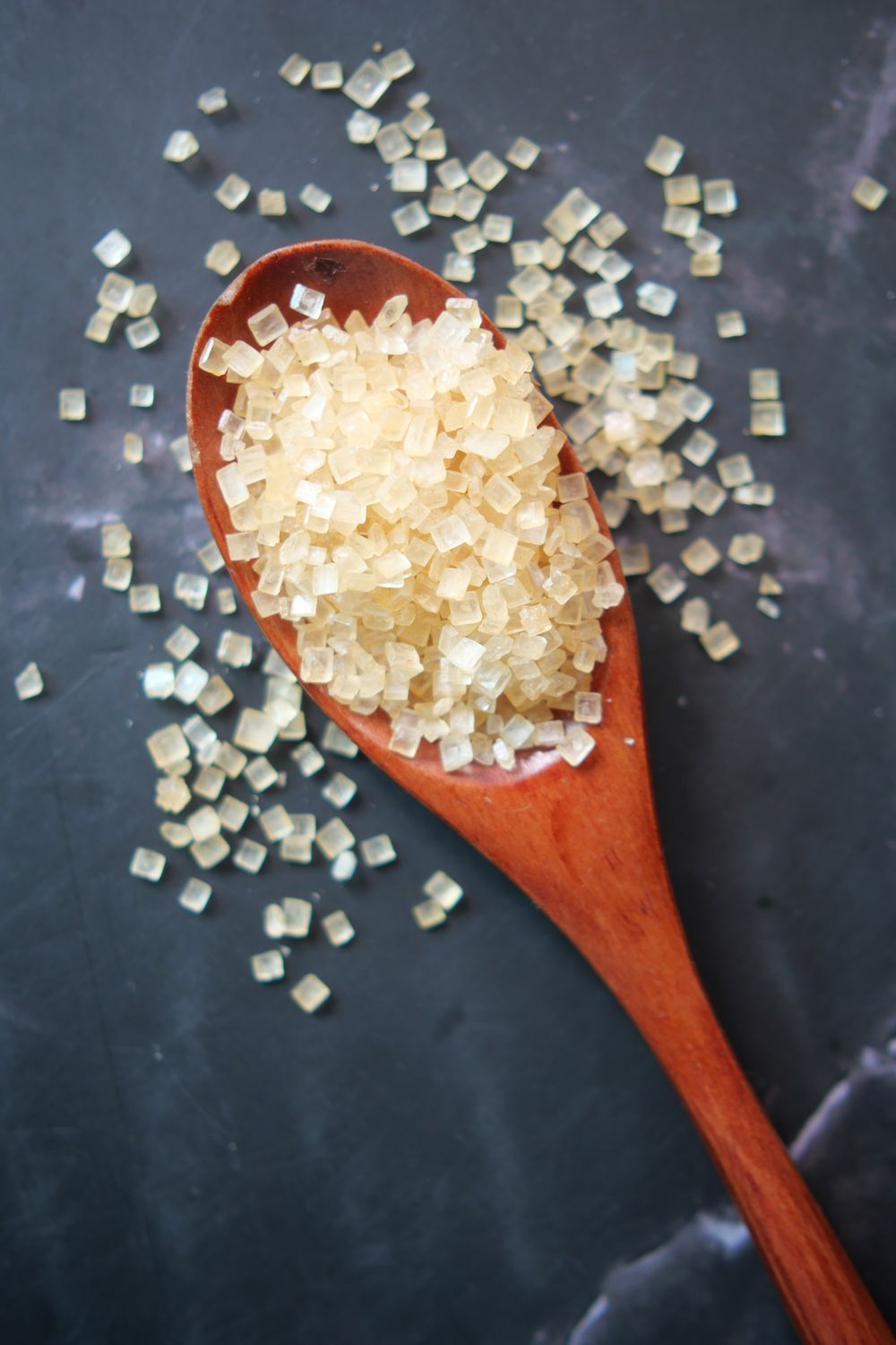 Raw Cane Brown Sugar Crystals on Wooden Spoon