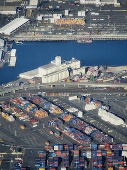 High-angle aerial view of a bustling shipyard filled with colorful cargo containers and facilities.