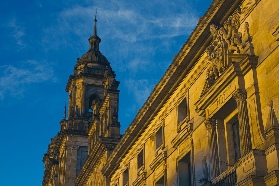Vista en ángulo bajo que resalta la arquitectura de una iglesia y torre barroca histórica.