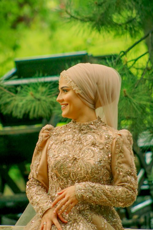 Free A young Muslim bride wearing an elegant, embroidered dress and hijab, posed outdoors. Stock Photo