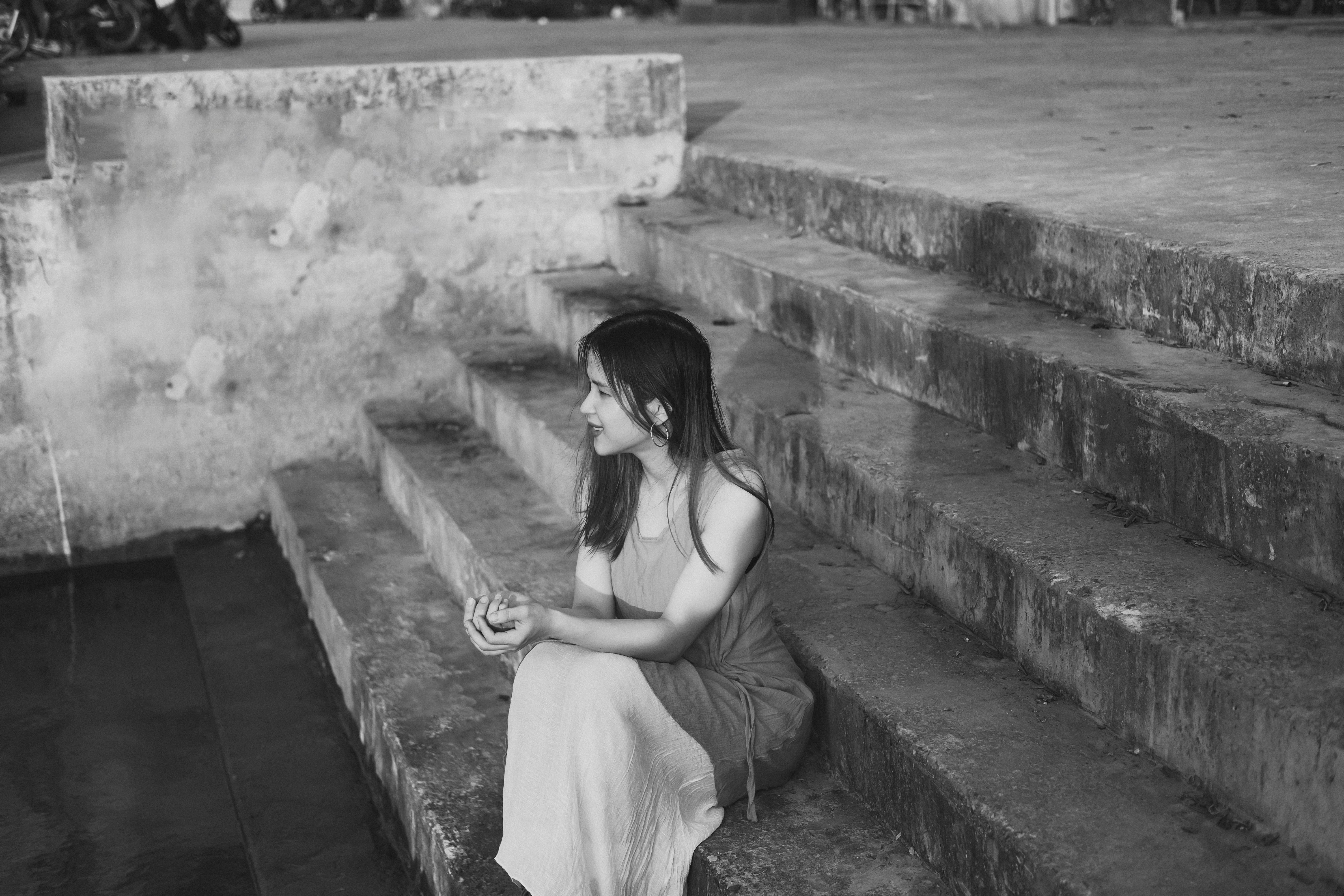 Woman in Gray Dress Sitting on Concrete Stairs · Free Stock Photo