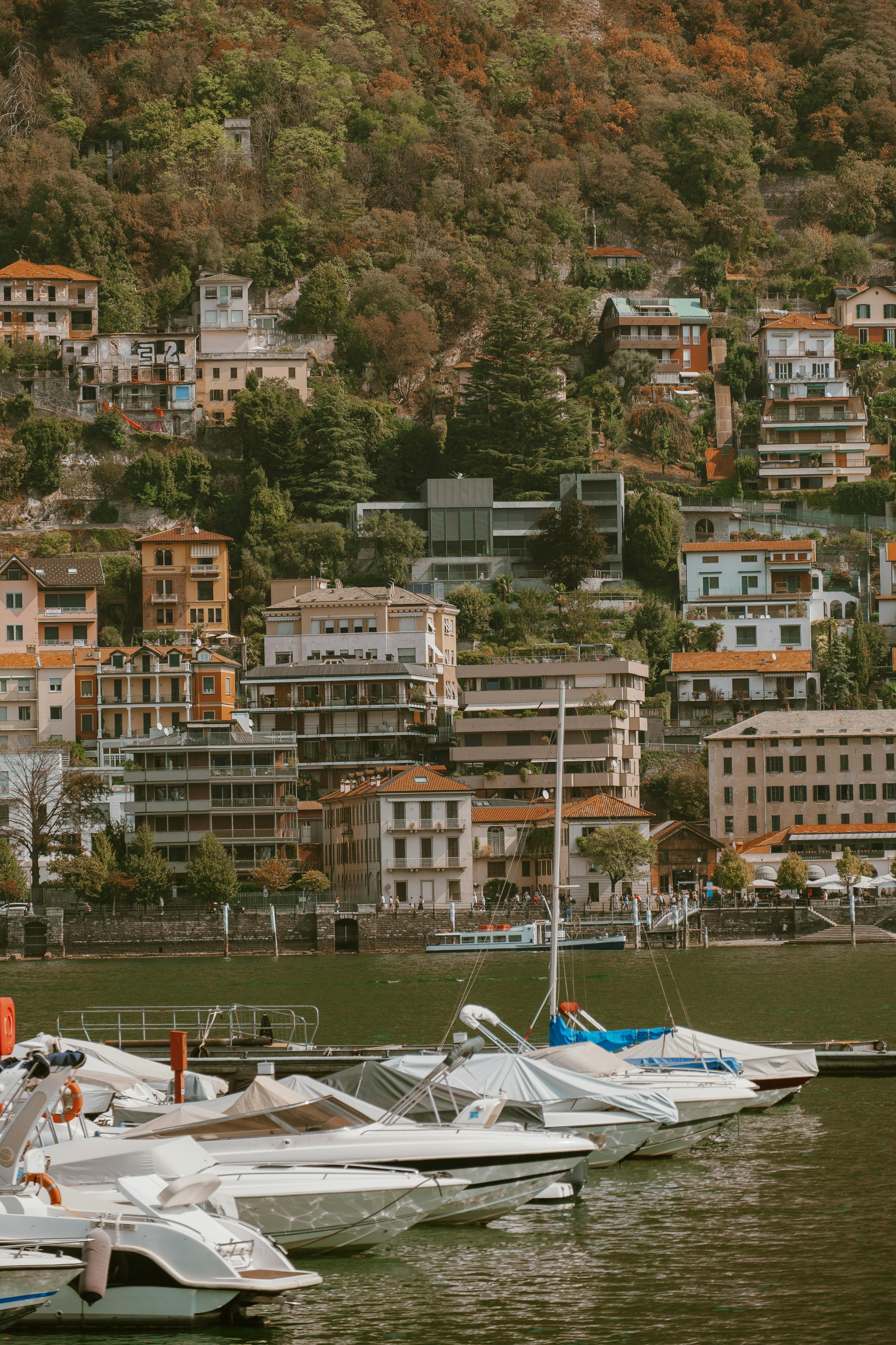 Charming harbor scene with boats and hillside villas in a Mediterranean town.