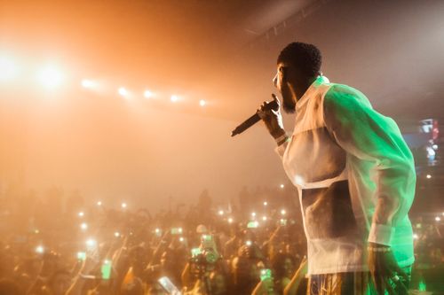 Free Dynamic scene of a performer on stage with a vibrant audience capturing the moment. Stock Photo
