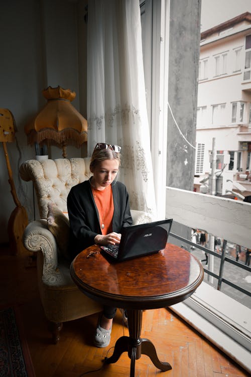 Woman Sitting in an Armchair Working on her Laptop
