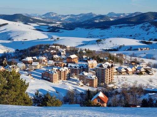 Free A picturesque winter village nestled in a snowy mountain landscape, capturing the beauty of winter. Stock Photo