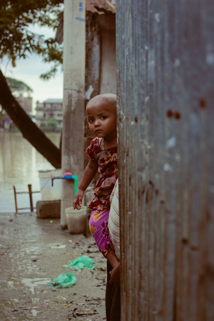 A Toddler Behind Corrugated Iron Sheets