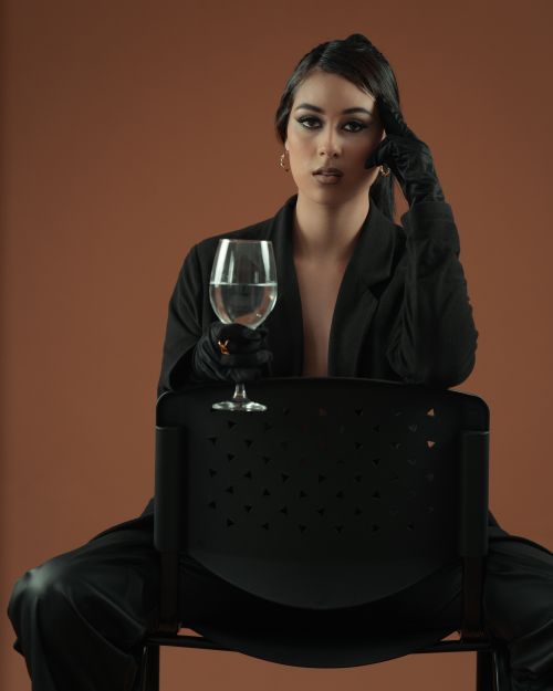 Free Portrait of a woman holding a wineglass, dressed in black attire, in a studio setting in Pitalito, Colombia. Stock Photo