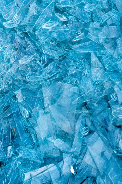 Free Vibrant close-up image of shattered blue glass with sharp edges and intricate patterns. Stock Photo
